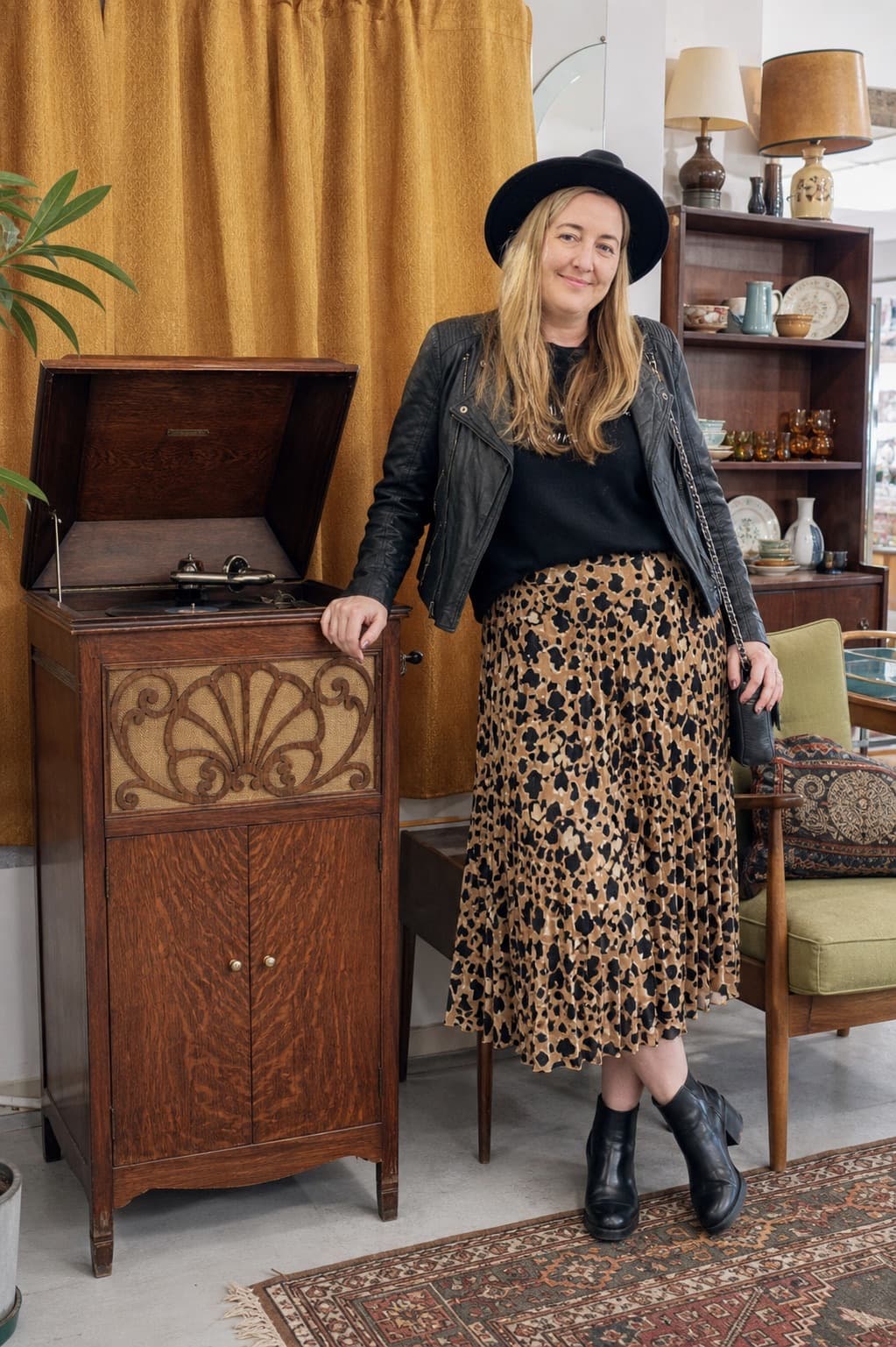 Claire Byrne beside a vintage record cabinet inside an op shop